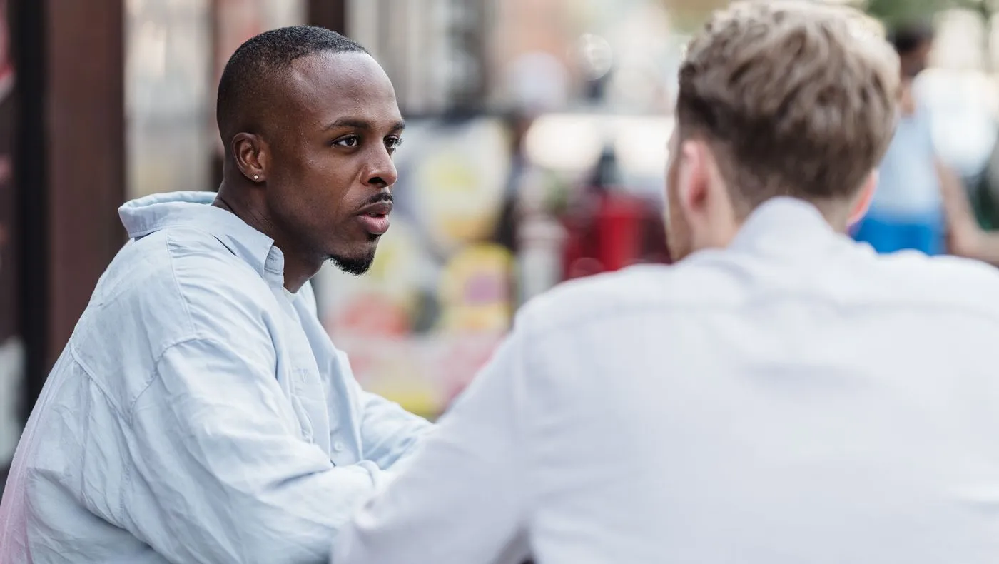 Two people talking closely in daylight