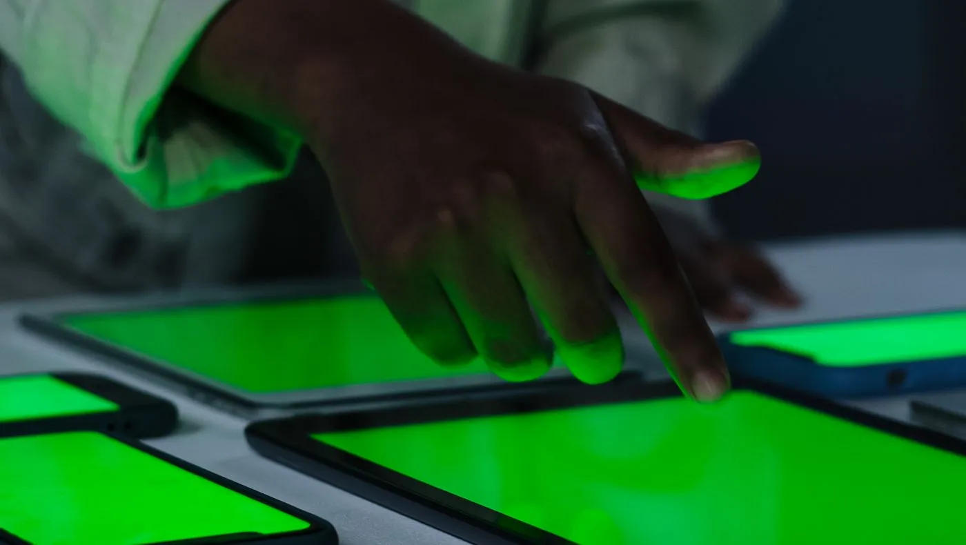 A child's hands on a glowing tablet screen