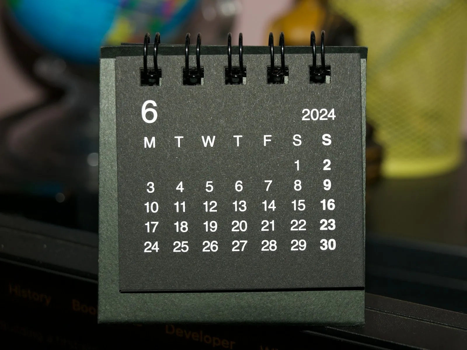 A desk calendar with the days of the month in view, lit from the side