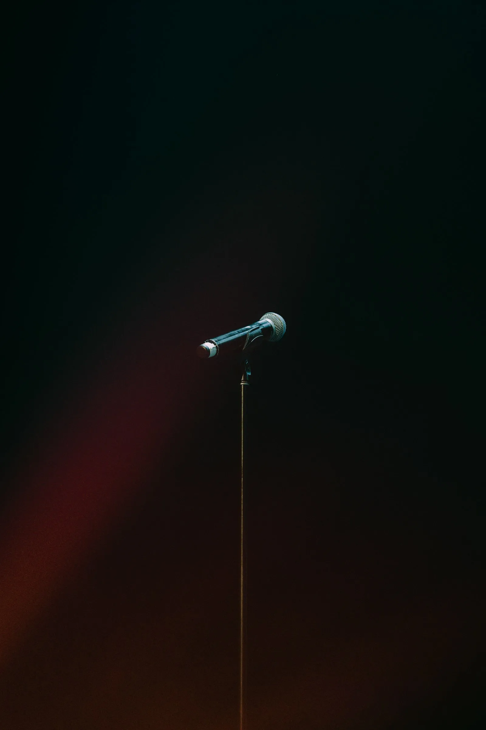 A single microphone standing in an empty, dimly lit room