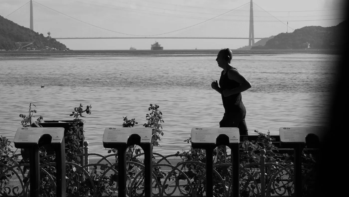 A runner on a path beside the water at dawn