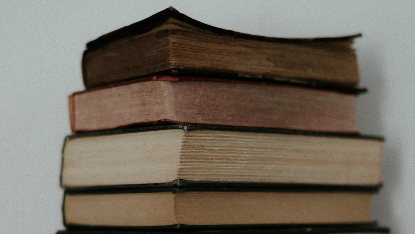 A stack of hardcover books on a table