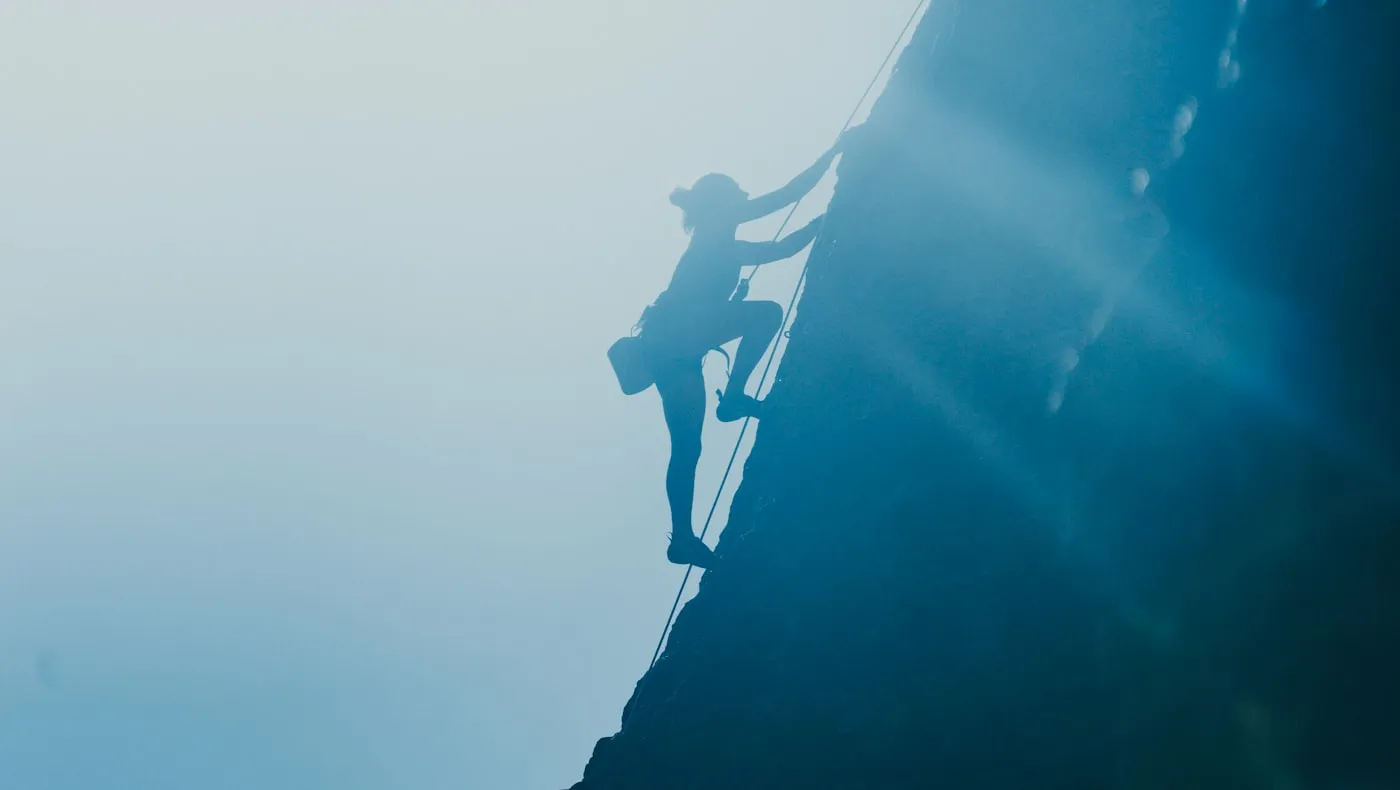 A climber silhouetted against a steep rock face