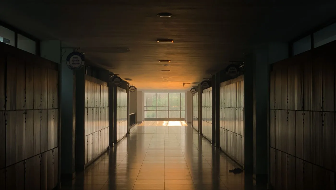 An office corridor with light at the far end