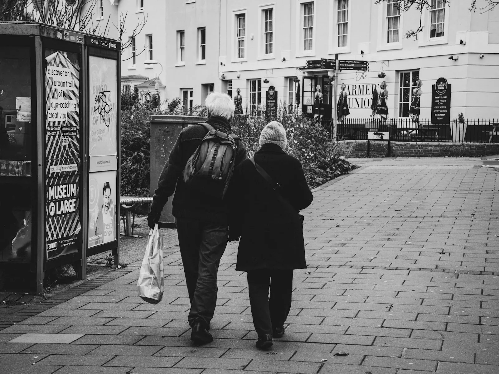 Two people walking together down a street, seen from behind