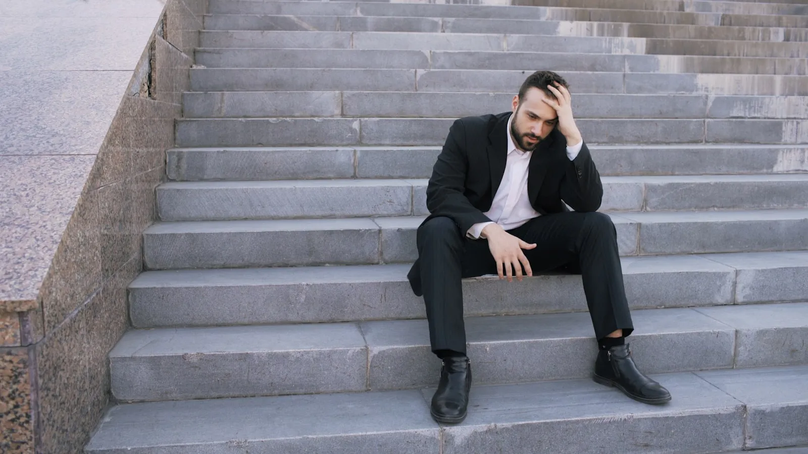 A person sitting alone on a set of stone steps