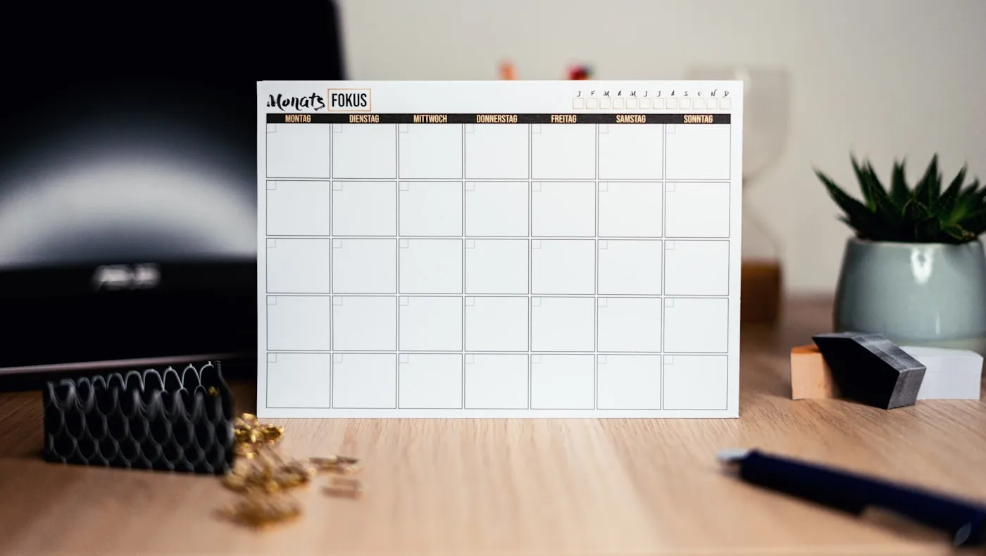 A blank monthly calendar standing on a desk